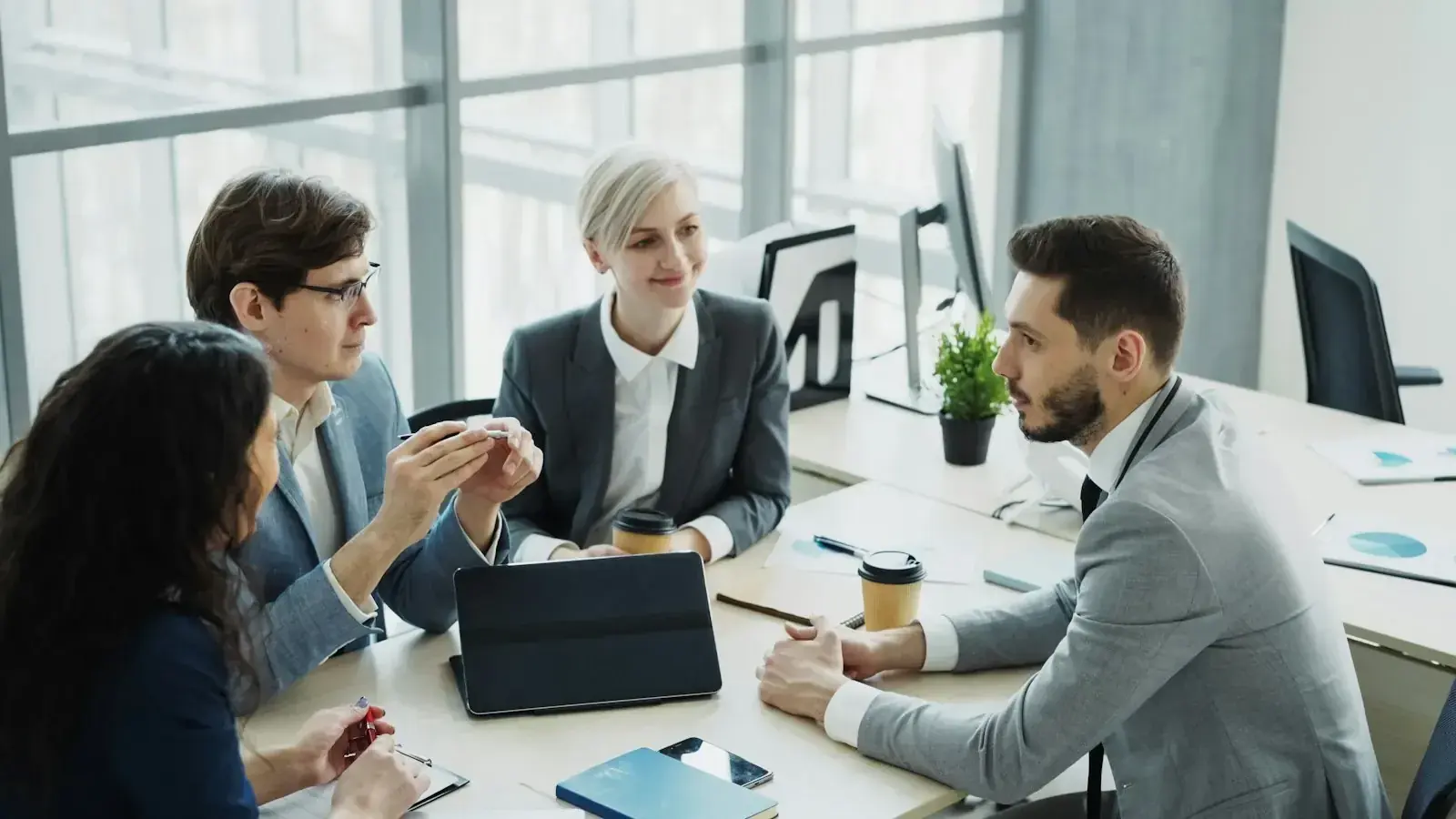 Business professionals collaborating around a table, representing a global mobility management company coordinating an international assignment