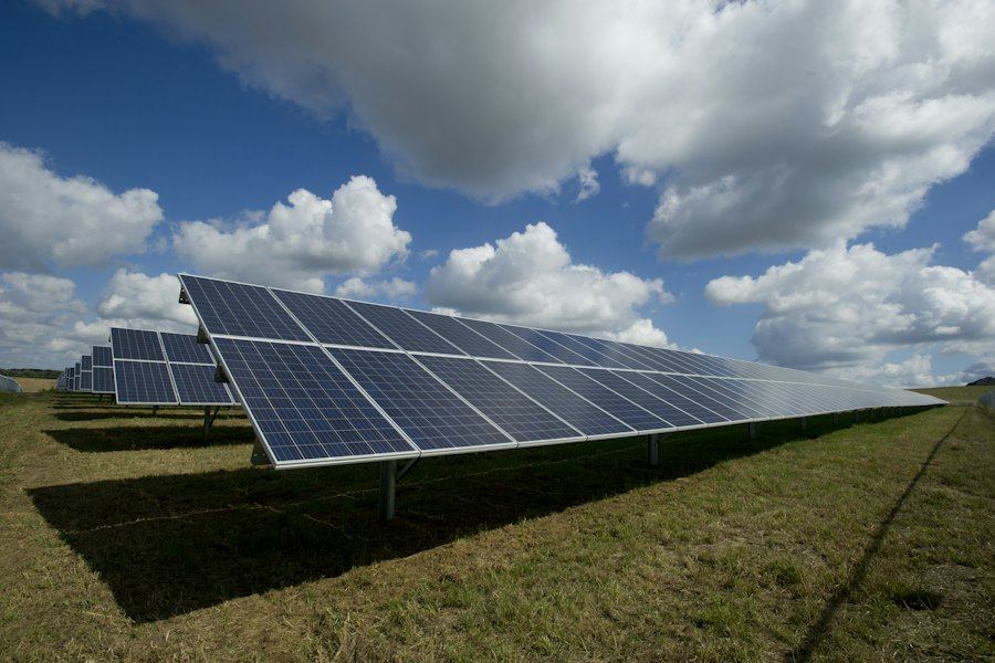 Solar panel array in an open field under a blue sky