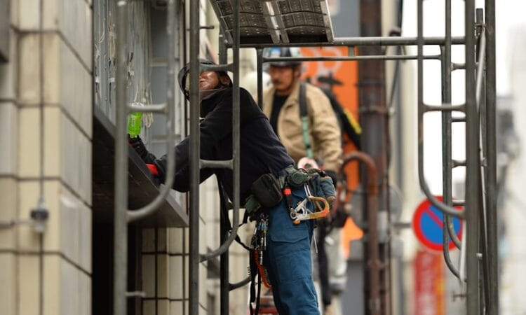 two men standing on scaffolding