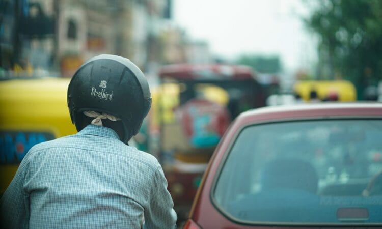 a person in a helmet looking at a car