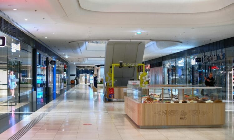 Spacious shopping mall interior in Bratislava with shops, escalators, and vibrant lighting.
