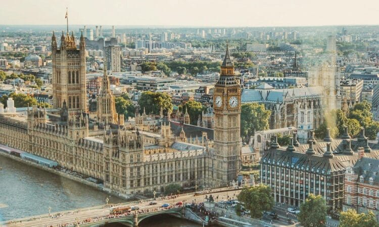 Stunning aerial view of London's iconic Big Ben and the river Thames under daylight.