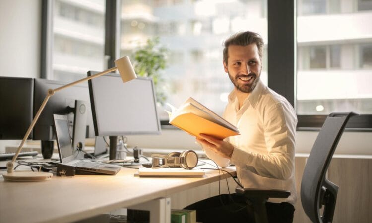 A relaxed businessman enjoying a break in his bright, contemporary office environment.