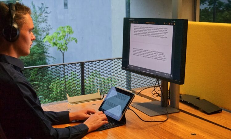 person in black long sleeve shirt using macbook pro on brown wooden table