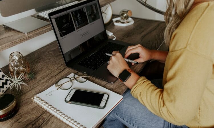 person in blue denim jeans using macbook pro