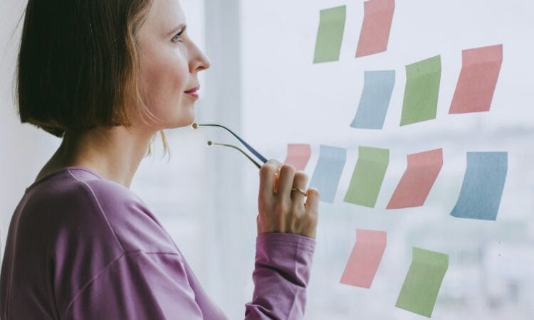 a woman looking out a window with sticky notes on it