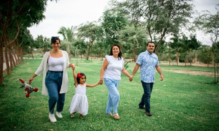 a group of people walking across a lush green field