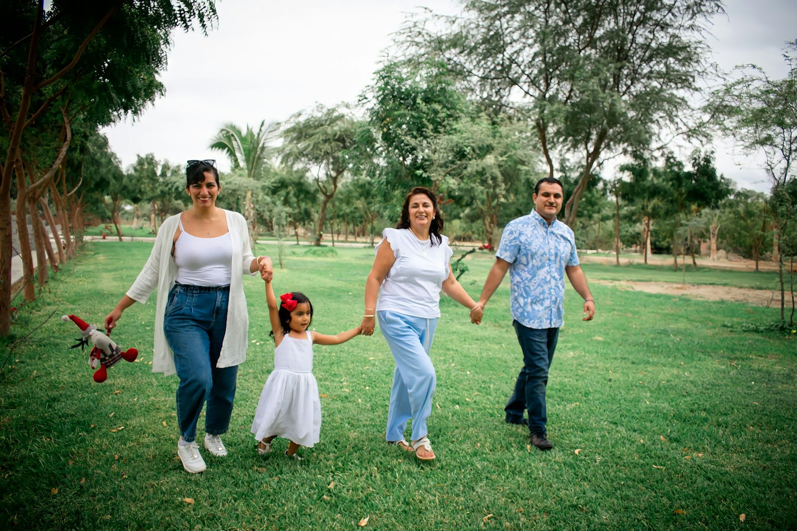 a group of people walking across a lush green field