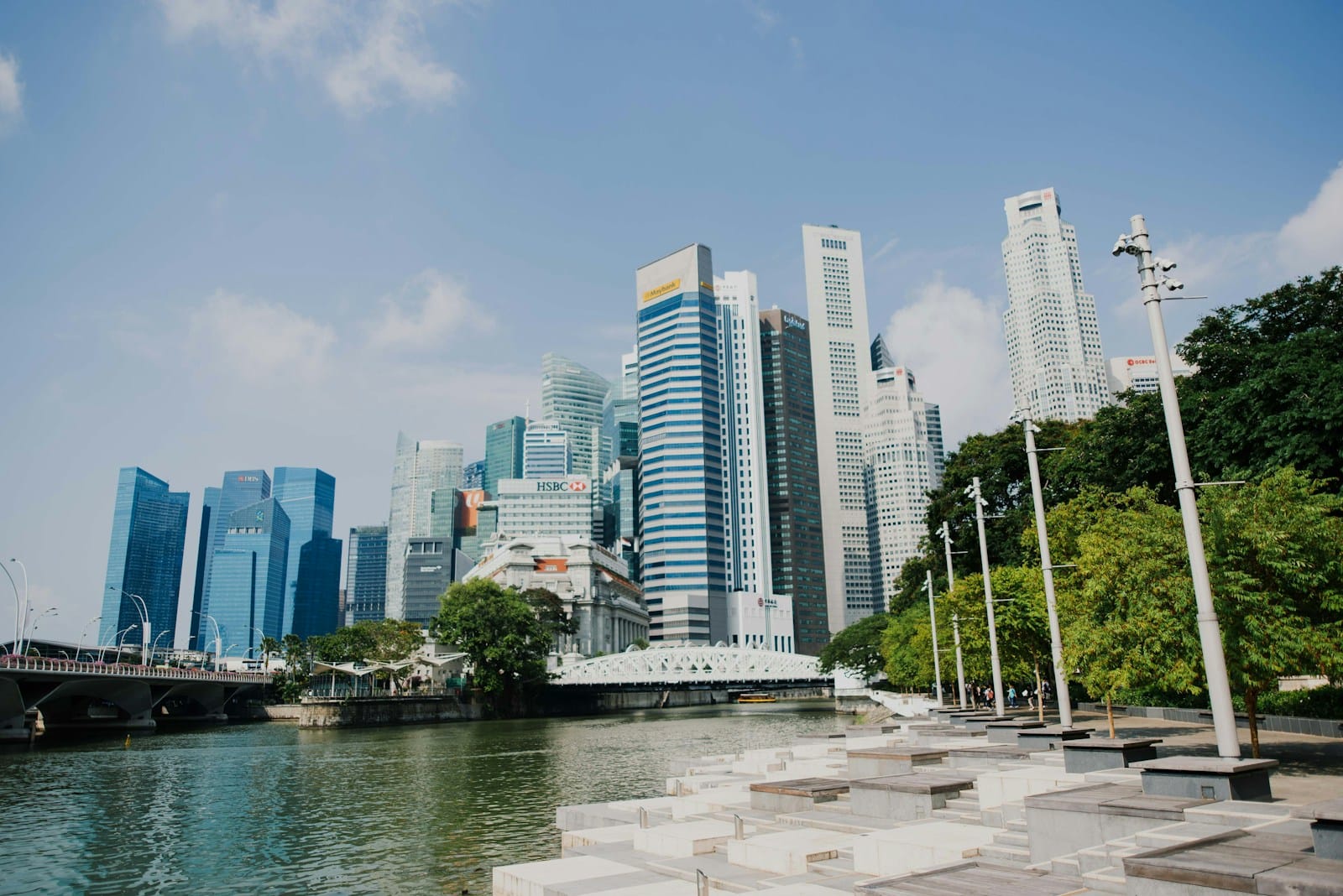 city skyline near water and bridge