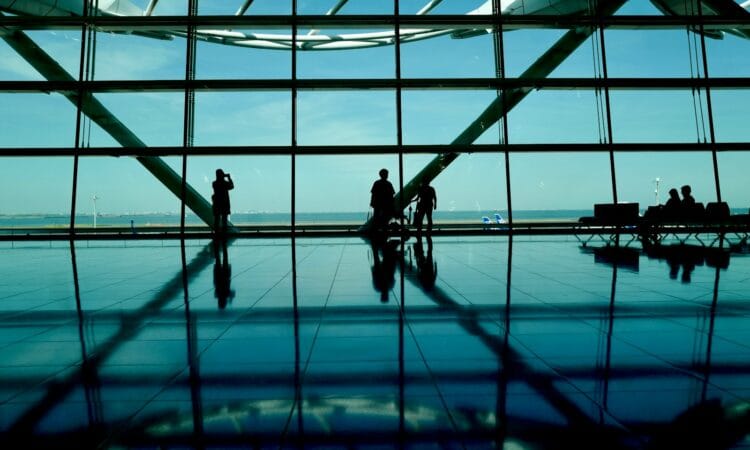 A couple of people standing in front of a window