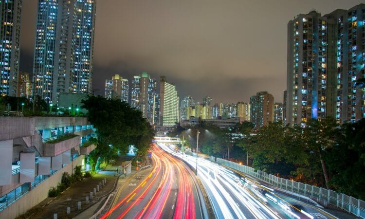 a city street filled with lots of traffic next to tall buildings