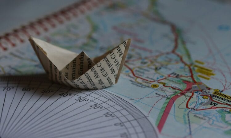 A paper boat sits on a map.