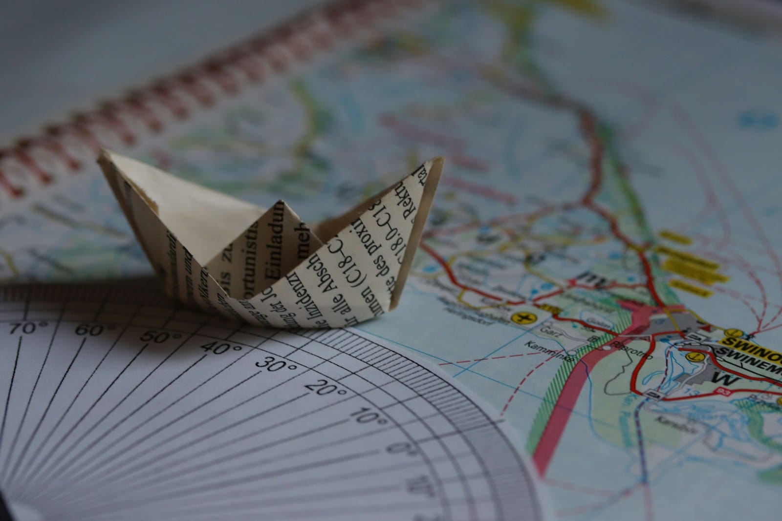 A paper boat sits on a map.