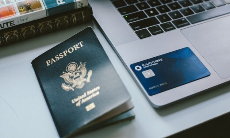 a passport sitting next to a laptop on a desk