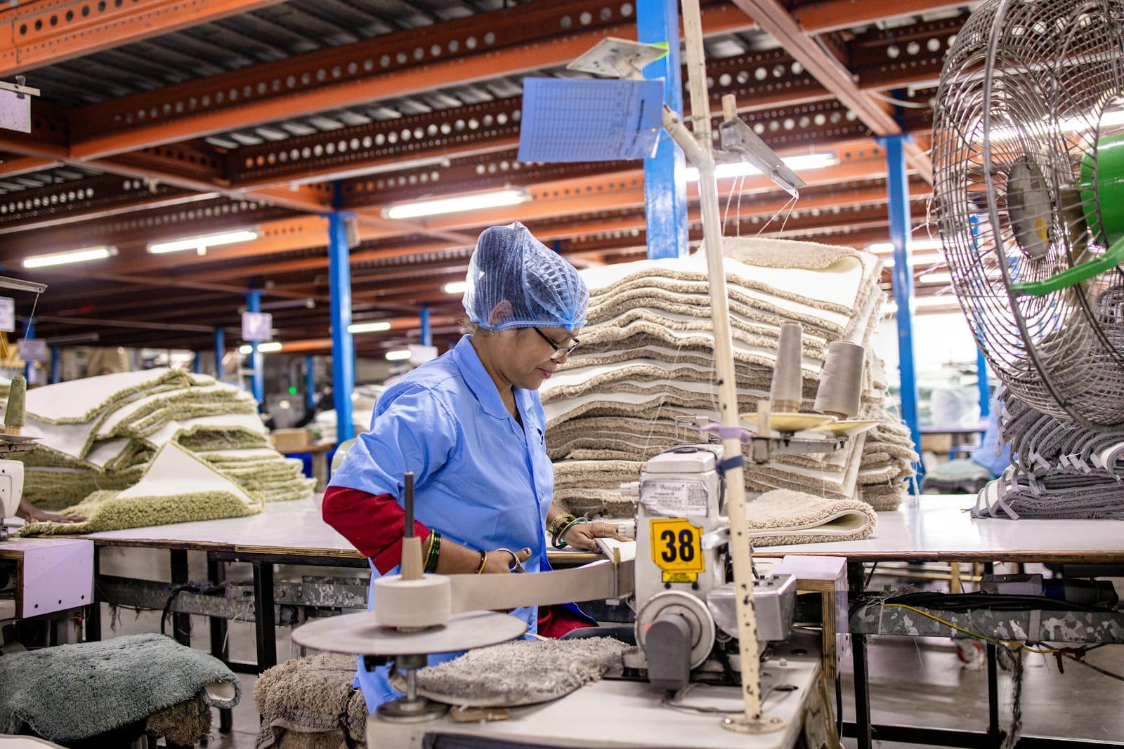 A worker operates machinery in a textile factory.