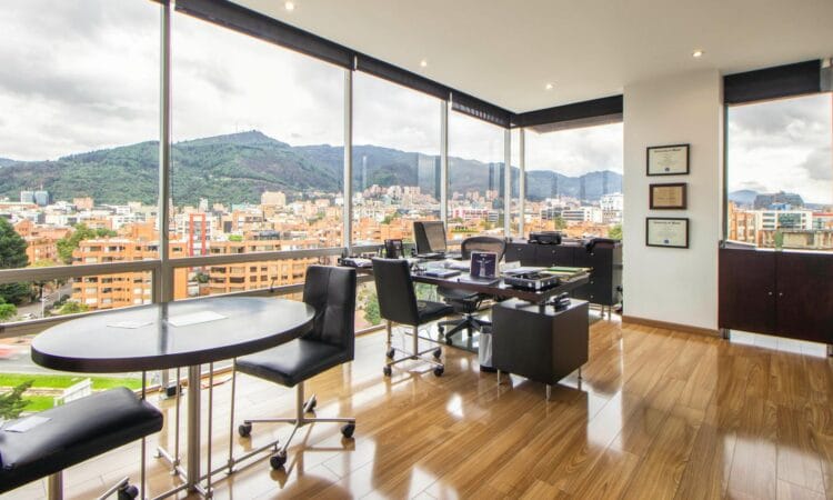 Spacious modern office with a scenic city view through glass windows.