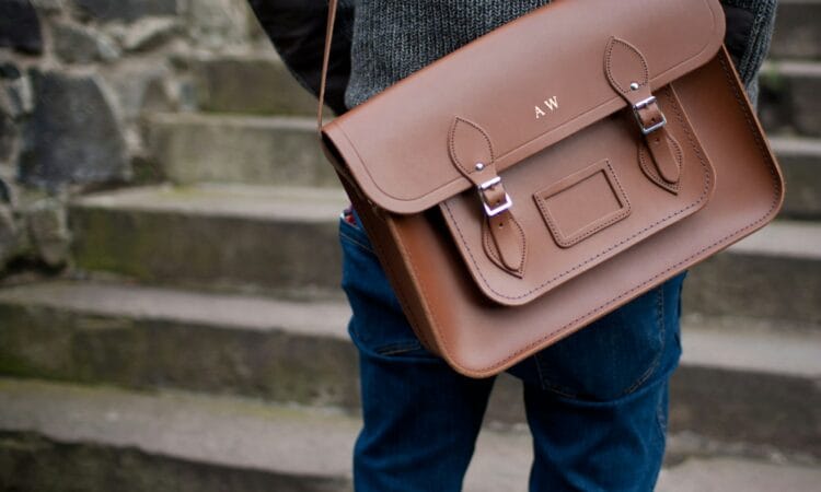 person carrying brown leather shoulder bag