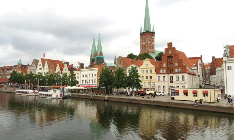 Picturesque waterfront view of historic buildings in Lübeck, Germany, reflecting in a canal.
